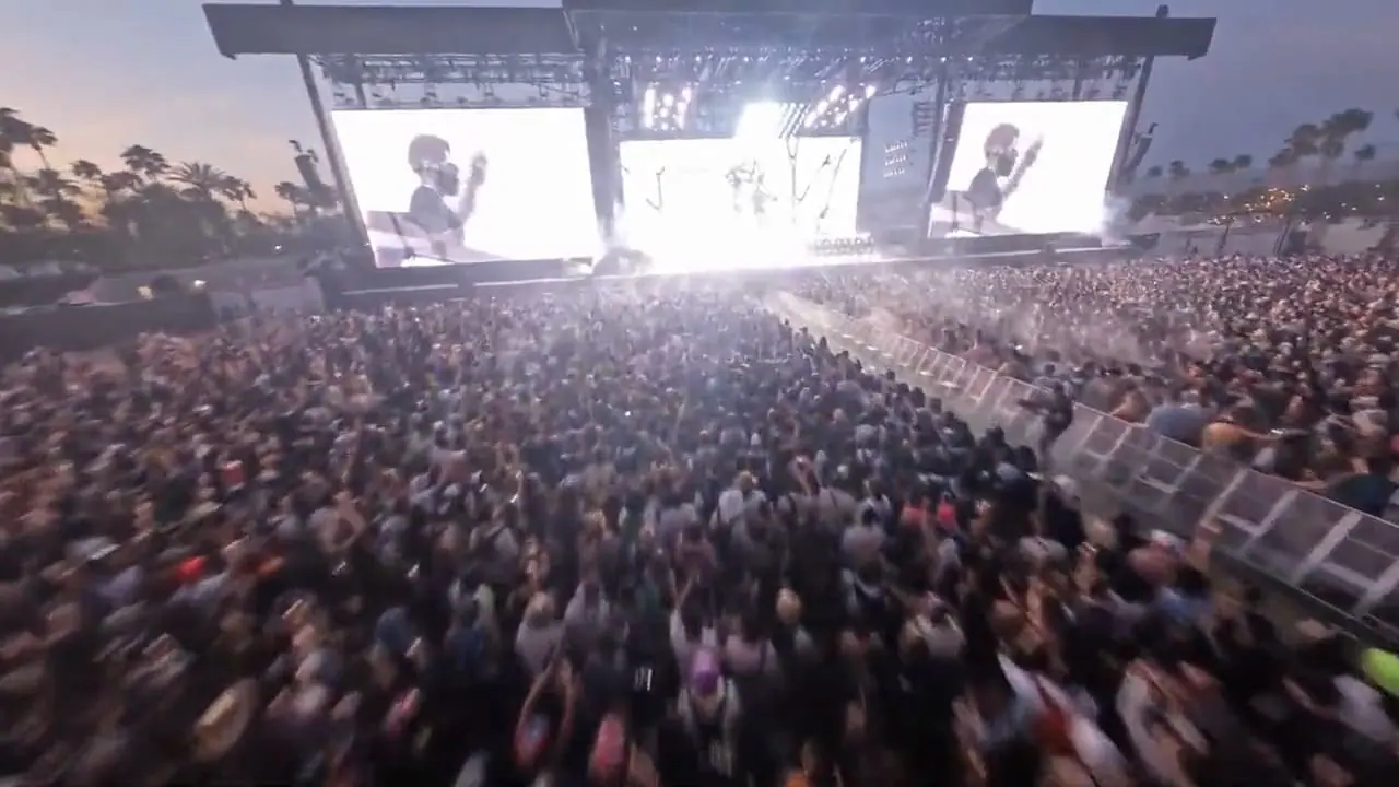 Festival crowd facing a lit main stage at dusk (atmosphere reel)